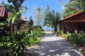 einen Weg zwischen zwei Häusern mit Bäumen und einem Gebäude in der Unterkunft Thai House Beach Resort in Ko Lanta