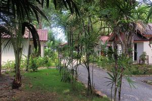 a group of trees in front of a house at Thai House Beach Resort in Ko Lanta