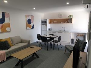 a living room with a couch and a table and a kitchen at Twofold Bay Motor Inn in Eden