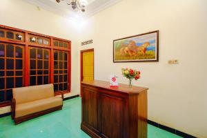 a waiting room with a chair and a vase of flowers at OYO 2047 Opak Village Bed & Breakfast in Bantul