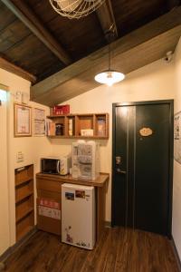 a kitchen with a refrigerator and a microwave at Qu Hi Home Stay in Jiufen