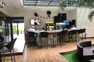 un groupe de personnes assises au bar d'un restaurant dans l'établissement Exquisite condo in magnificent La Grande Resort, à Ángeles