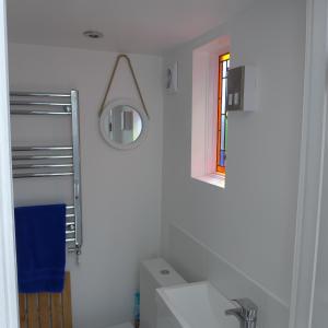a white bathroom with a sink and a mirror at Sea Glimpses with garden, beachhut, parking in Broadstairs
