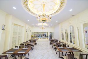 廊开The MACEO Hotel的餐厅设有木桌、椅子和吊灯。
