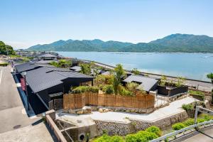 an aerial view of a building next to a body of water at Miyajima Hanarenoyado IBUKU Bettei All rooms have an open-air bath in Ōno