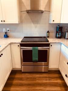 a kitchen with a stove with a green towel on it at Botany Bay by Eagle Reach Properties in Port Renfrew