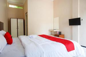 Giường trong phòng chung tại RedDoorz near Taman Mini Jakarta