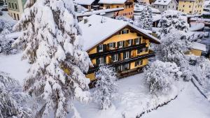 a building covered in snow next to some trees at AppartChalet LA RONDULA - 100m from Seceda in Ortisei +172 photos
