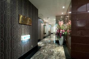 un corridoio di un hotel con fiori sul muro di HOTEL PERRIER (Adult Only) a Tokyo