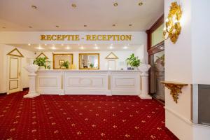 - un hall d'accueil avec une réception et un tapis rouge dans l'établissement Hotel Cetate, à Alba Iulia