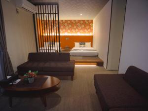 uma sala de estar com um sofá e uma cama em GRAND BASE Hakata Sumiyoshi em Fukuoka