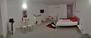 a small white room with a bed and a table at la staccionata bianca in Viterbo
