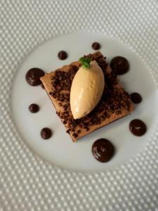 a white plate with a piece of cake and ice cream on it at Saveurs De l'Abbaye in Saintes