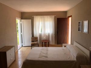 a bedroom with a bed and a chair and a window at Villa tosalet in Jávea