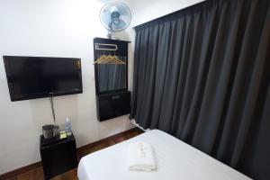Habitación de hotel con 1 cama, TV, 1 cama y 1 sofá cama en Tune Hotel - Waterfront Kuching, en Kuching