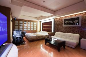 東京的住宿－佩里耶酒店（僅限成人），一间卧室配有一张床、一张沙发和一台电视。