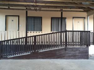 a black railing in front of a building with two doors at Transit Motel in Mulifanua