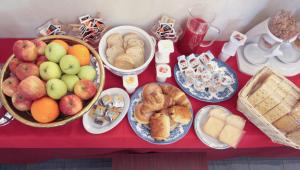a red table topped with lots of different types of food at Hotel Rose&Crown in Correggio