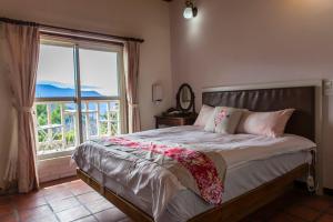 a bedroom with a bed with a large window at Shan Shui-Yuan Vege Guest House in Ren'ai