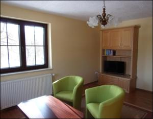 sala de estar con 2 sillas verdes y mesa en Ferienwohnung Kohrener Land, en Kohren-Sahlis