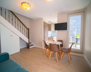 a living room with a table and chairs and a staircase at Vila JŪRALUX in Palanga