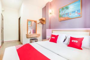 a bedroom with a large bed with red pillows at Super OYO 44088 Valley View Hotel in Lumut