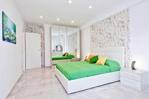 um quarto com uma cama grande com almofadas verdes e amarelas em Maison Roberta San Peter em Roma