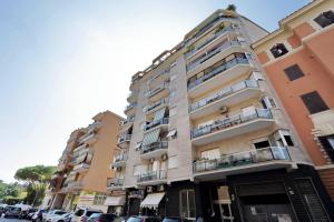 un grand bâtiment avec des voitures garées devant dans l'établissement Maison Roberta San Peter, à Rome