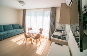 a living room with a table and chairs and a couch at Vila JŪRALUX in Palanga