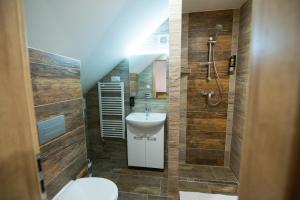 a bathroom with a sink and a toilet and a shower at Villa Michaela in Bešeňová