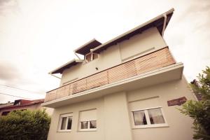 a white house with a balcony on top of it at Rooms Medved in Samobor