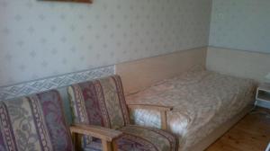 a small bedroom with a bed and a chair at Transvaali 28 B&B in Kuressaare