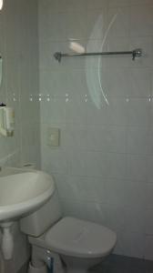 a white bathroom with a toilet and a sink at Transvaali 28 B&B in Kuressaare