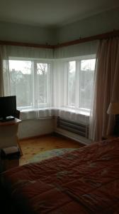 a bedroom with two windows and a bed and a desk at Transvaali 28 B&B in Kuressaare