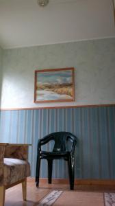 una silla negra en una habitación con una pintura en la pared en Transvaali 28 B&B, en Kuressaare