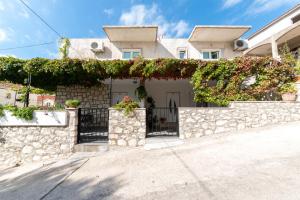 una casa con una valla de piedra y hiedra en Apartments Mate, en Bol