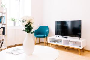 a white vase with flowers on a table in a living room at Bright, central and stylish city apartment in Vienna