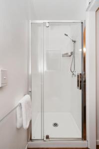 a shower with a glass door in a bathroom at Auckland Airport Motel in Auckland