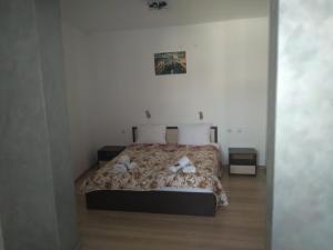 a bedroom with a bed with two teddy bears on it at Семеен Хотел Дани in Asenovgrad