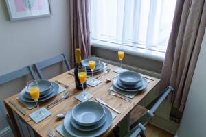 uma mesa de madeira com pratos e copos de sumo de laranja em William House em Chester