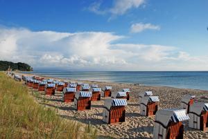 a row of beach chairs on a sandy beach at Ferienappartements Familie Lenz in Sehlen