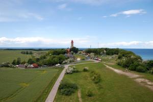 a road leading to a lighthouse on a hill next to the ocean at Ferienappartements Familie Lenz in Sehlen