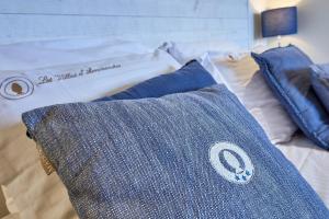 a bed with two blue pillows on top of it at Les Villas d'Arromanches, Teritoria in Arromanches-les-Bains