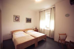1 dormitorio con 2 camas y ventana en Rooms Medved, en Samobor