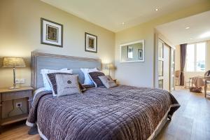 a bedroom with a large bed with pillows at Les Villas d'Arromanches, Teritoria in Arromanches-les-Bains