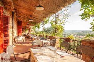 un restaurante con mesas y sillas en un balcón en Hotel Il Castello, en Certaldo