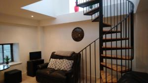 a spiral staircase in a living room with a couch at 10 The Kiln in Westport