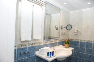 a bathroom with a sink and a mirror at Mastichari Bay Hotel in Mastihari