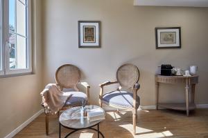 a living room with two chairs and a table at Les Villas d'Arromanches, Teritoria in Arromanches-les-Bains