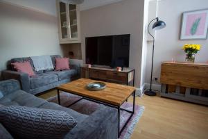 uma sala de estar com um sofá e uma mesa em William House em Chester